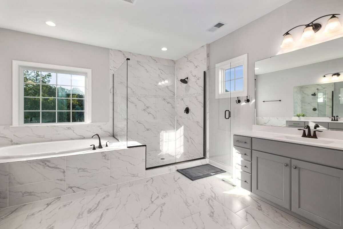 Modern spacious bathroom renovation in Mint Hill, NC with white tile floor and matching shower surround.